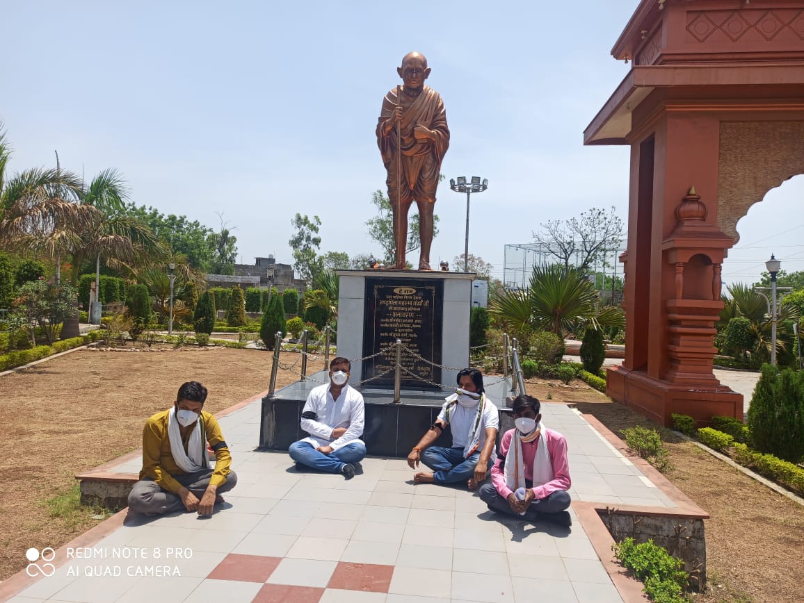 महात्मा गांधी की प्रतिमा के समक्ष बैठकर किया विरोध प्रदर्शन।